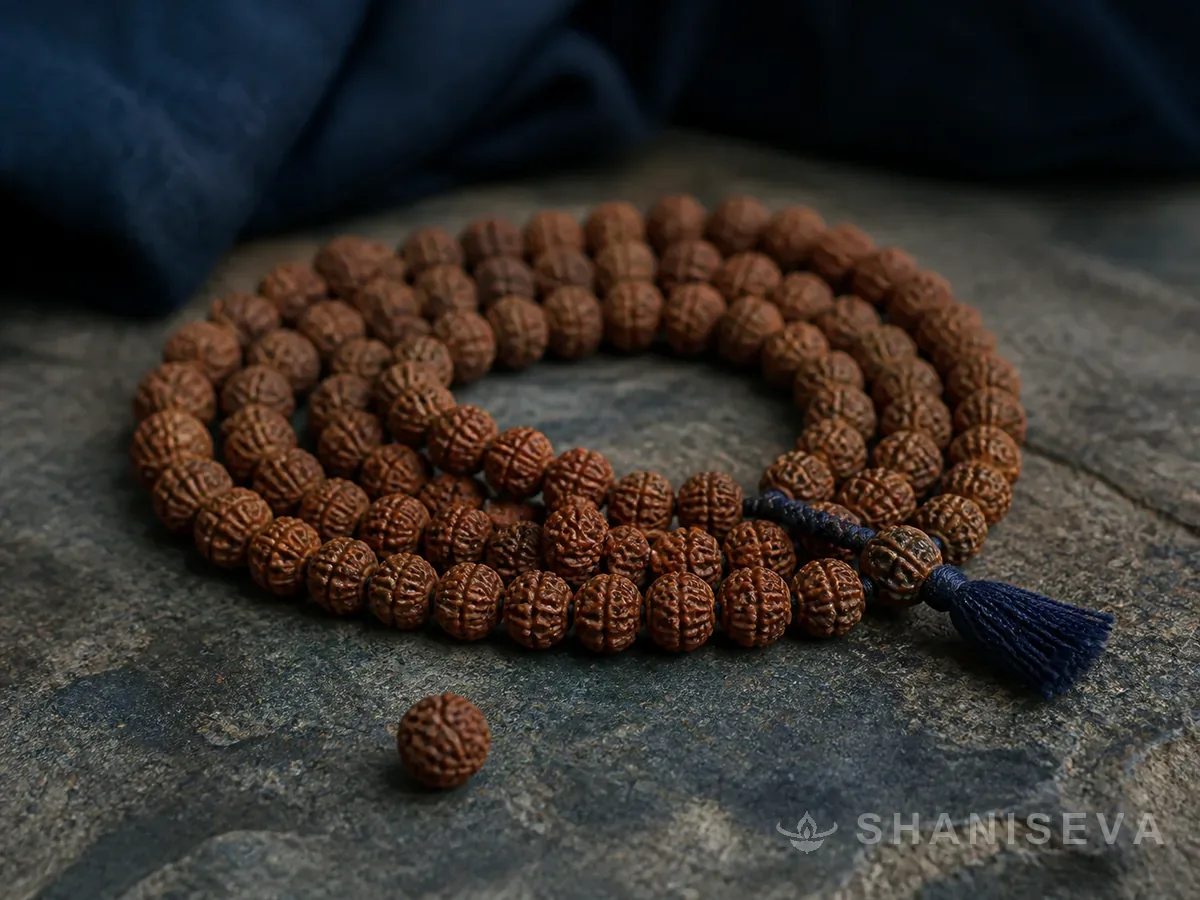 A rudraksha mala coiled on stone
